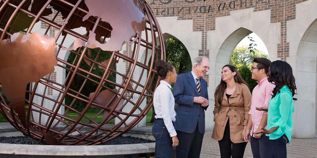 President Andreasen with students at the Andrews globe entrance